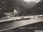 Výřez staré fotografie z roku 1930 zachycující železniční zastávku Jarov, přístaviště a projíždějící parník ze Slap na Prahu.