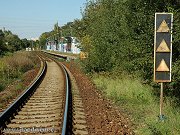 Oblouk ped zastvkou Praha-Komoany, kter je patrn v pozad. Napravo od koleje je vidt vzdlenostn upozorovadlo vjezdovho nvstidla do Modan. V pozad samotn vjezdov nvstidlo do Modan. Snmek z 20. z 2007.