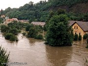 Rozbouřená řeka Vltava zaplavuje na Zbraslavi domky ležicí na pravém břehu. Snímek byl pořízen 13. srpna 2002, tedy ještě před dosažením maximální výšky hladiny. O den později byl stejný domek zatopen vodou až po horní římsu oken. Zároveň bylo toho dne zatopeno i kolejiště zbraslavské stanice.